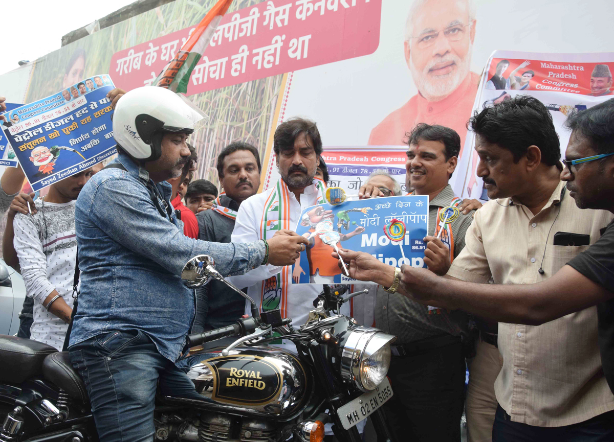 Today Protest Organized by Sayed Zeeshan Ahmed Secretary Maharashtra Pradesh Congress Committee Distributing Achche Din Ke "Modi Lolipop" at J.J.Junction Petrol Pump Against Frequent Rise and Fall of Petrol and Diesel Prices everyday Fooling Around Common